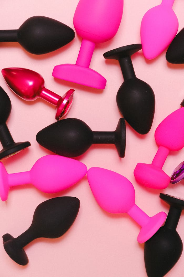 home-hero Bright and colorful collection of silicone adult toys on a pastel pink background.